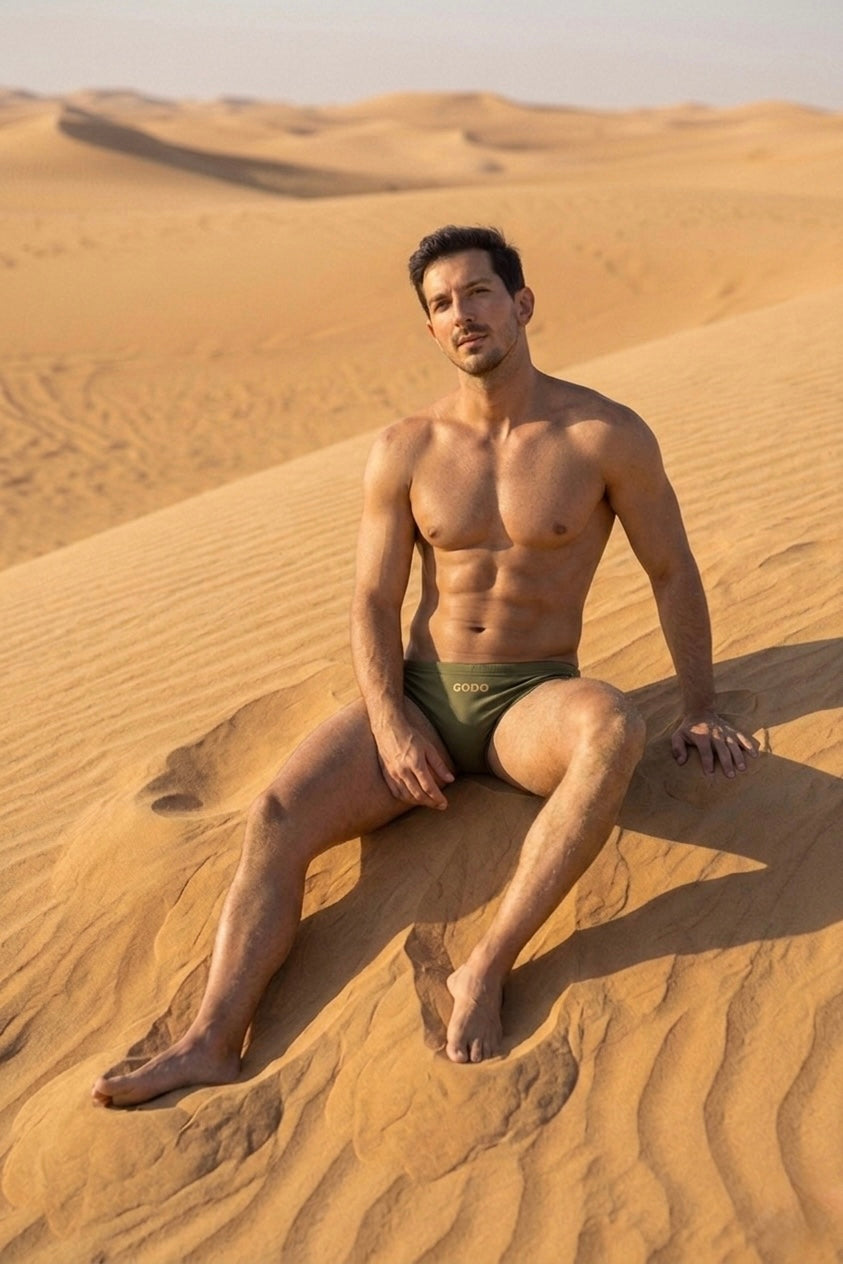 Man sitting on a sand dune in a desert landscape