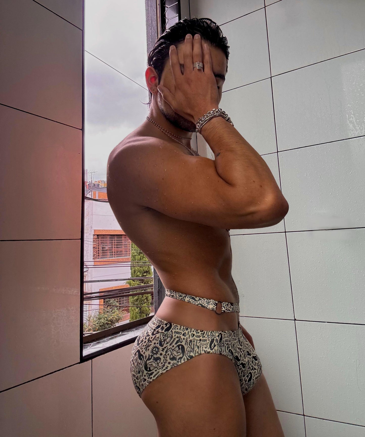 Person wearing patterned Thor swimwear standing in a tiled room.