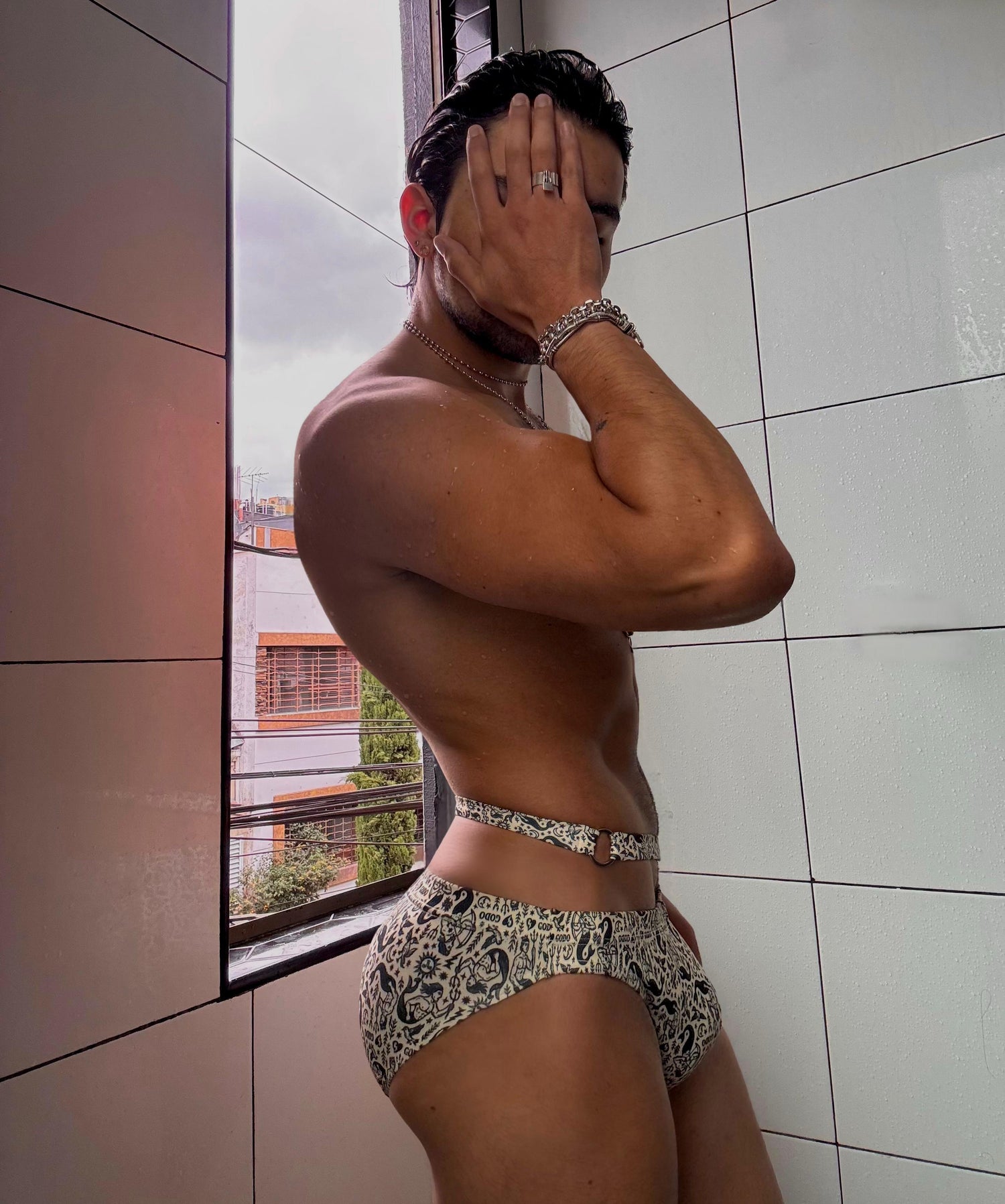 Person wearing patterned Thor swimwear standing in a tiled room.