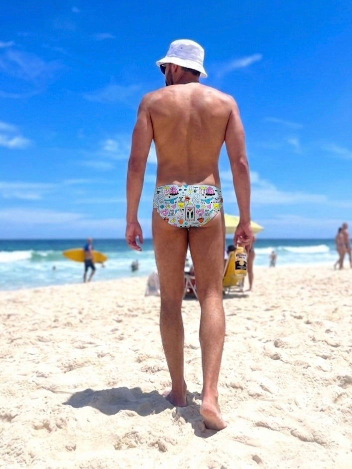 Man on the beach with blue swim brief of brand GODO