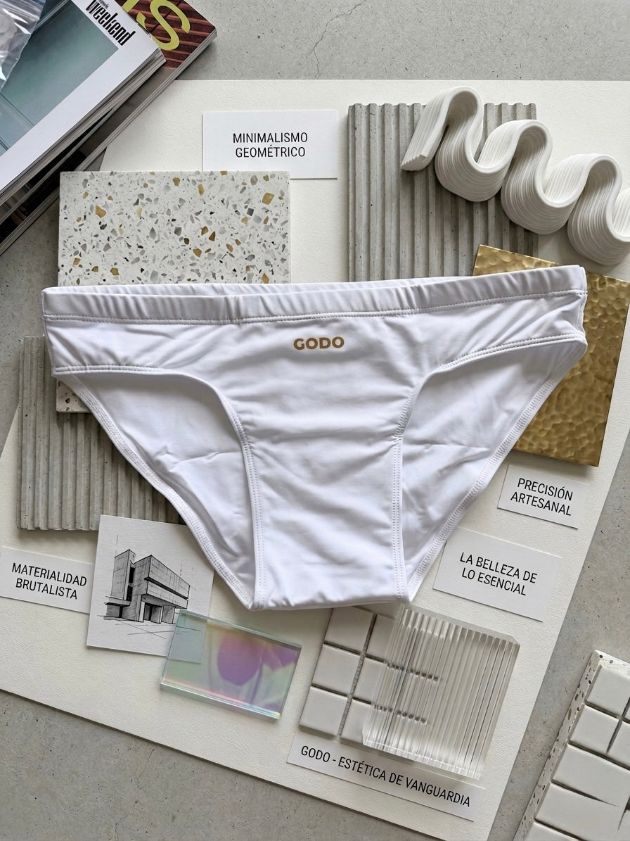 White swimwear with 'Godo' branding on a surface with architectural design samples.